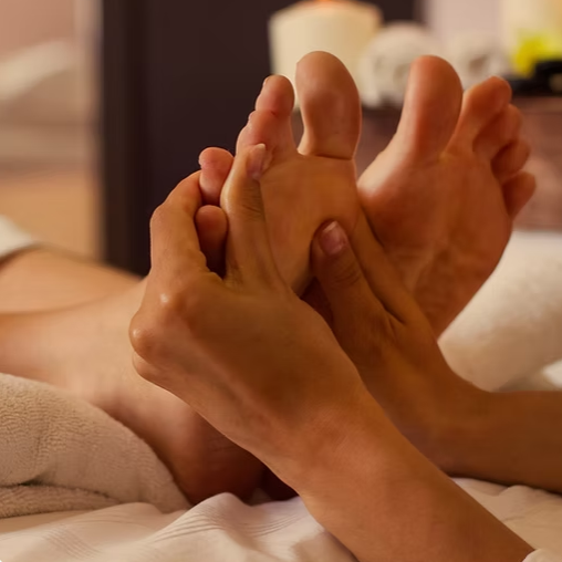 Hands working on the sole of a foot during a foot massage